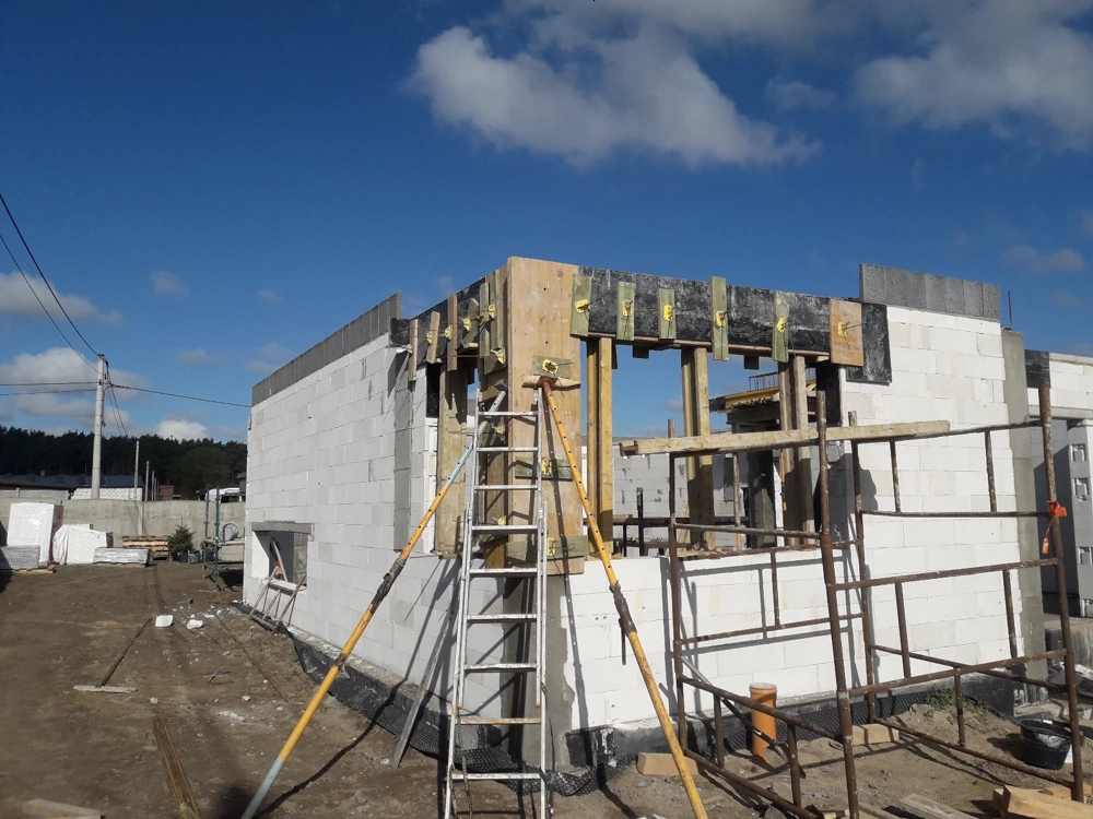 Stan surowy otwarty – murowanie ścian z bloczków i montaż szalunków nadproży na budowie domu