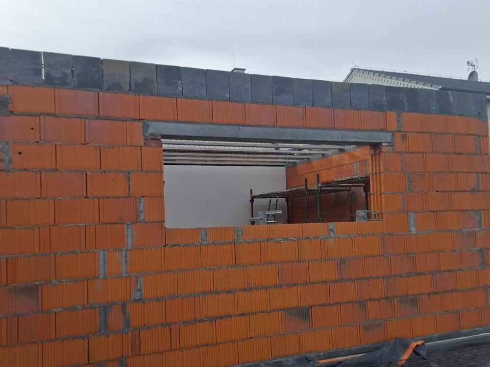 Stan surowy otwarty: murowanie ścian z pustaków ceramicznych z otworem okiennym i rusztowaniem