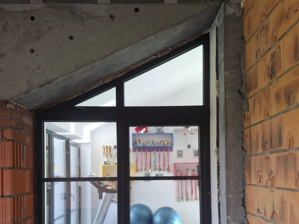 Okno aluminiowe osadzone w murze z cegły z betonowym nadprożem – stan surowy zamknięty