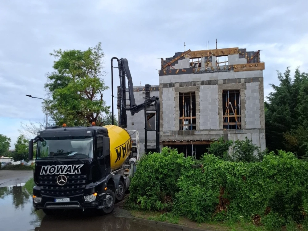 Betonowanie elementów żelbetowych betoniarką przy budynku