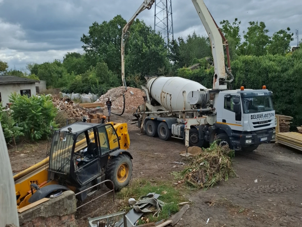 Ładowarka teleskopowa i betoniarka z pompą na placu budowy podczas prac ziemnych