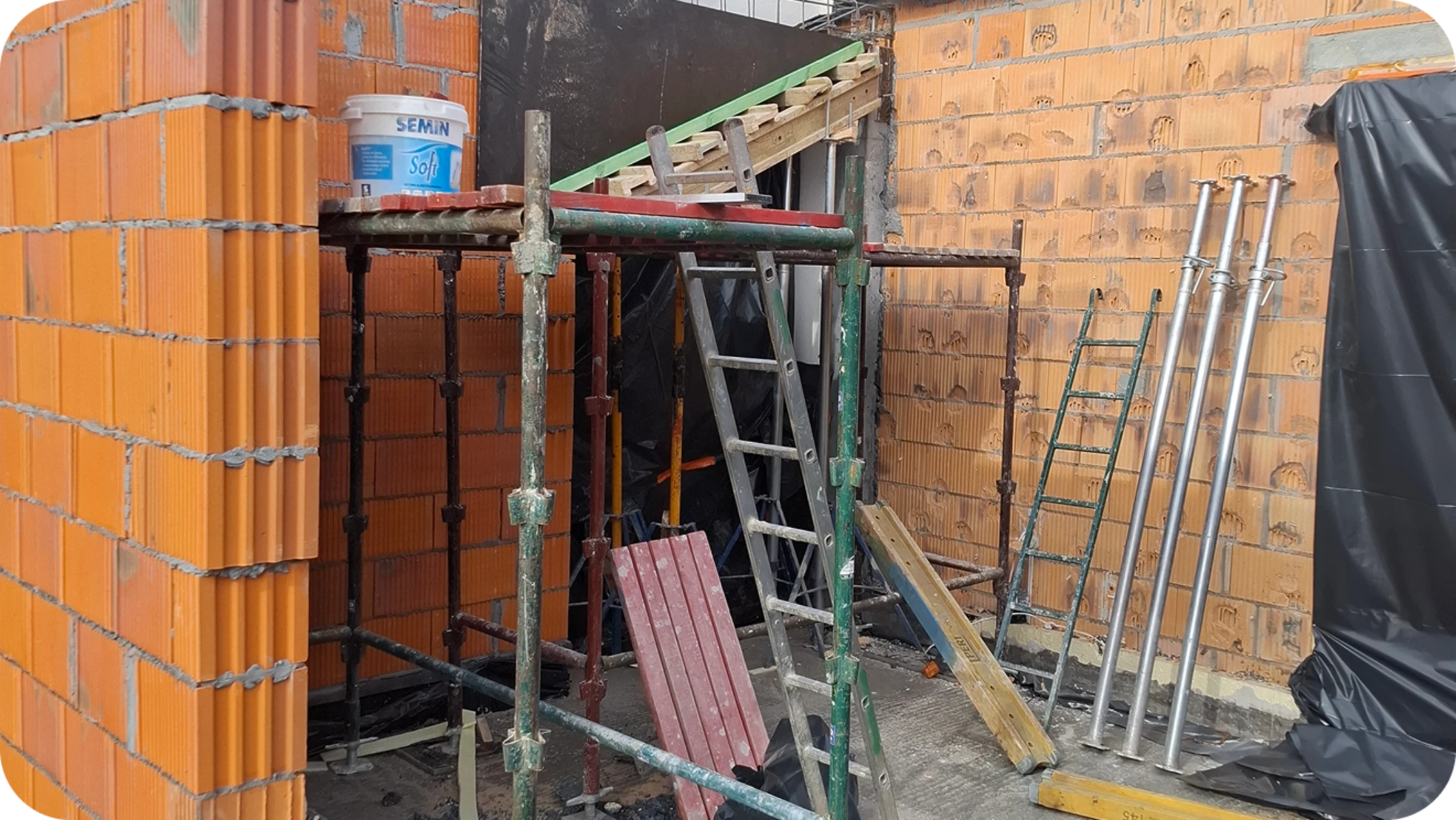 Plac budowy z murowanymi ścianami z pustaków i stelażem rusztowania – stan surowy otwarty