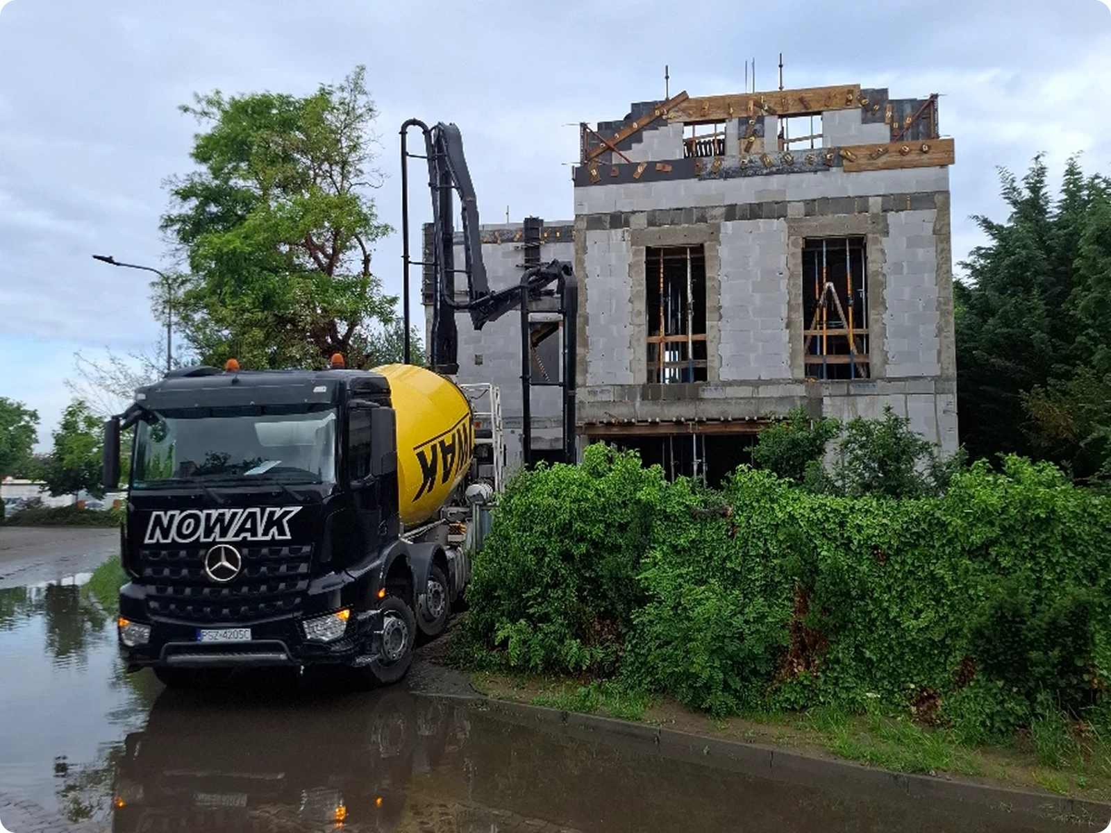 Betoniarka i pompa wylewają beton na budowie domu w stanie surowym otwartym