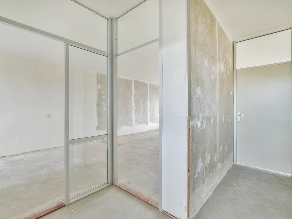 Wnętrze budynku w stanie surowym otwartym z nieotynkowanymi ścianami i metalowym stelażem