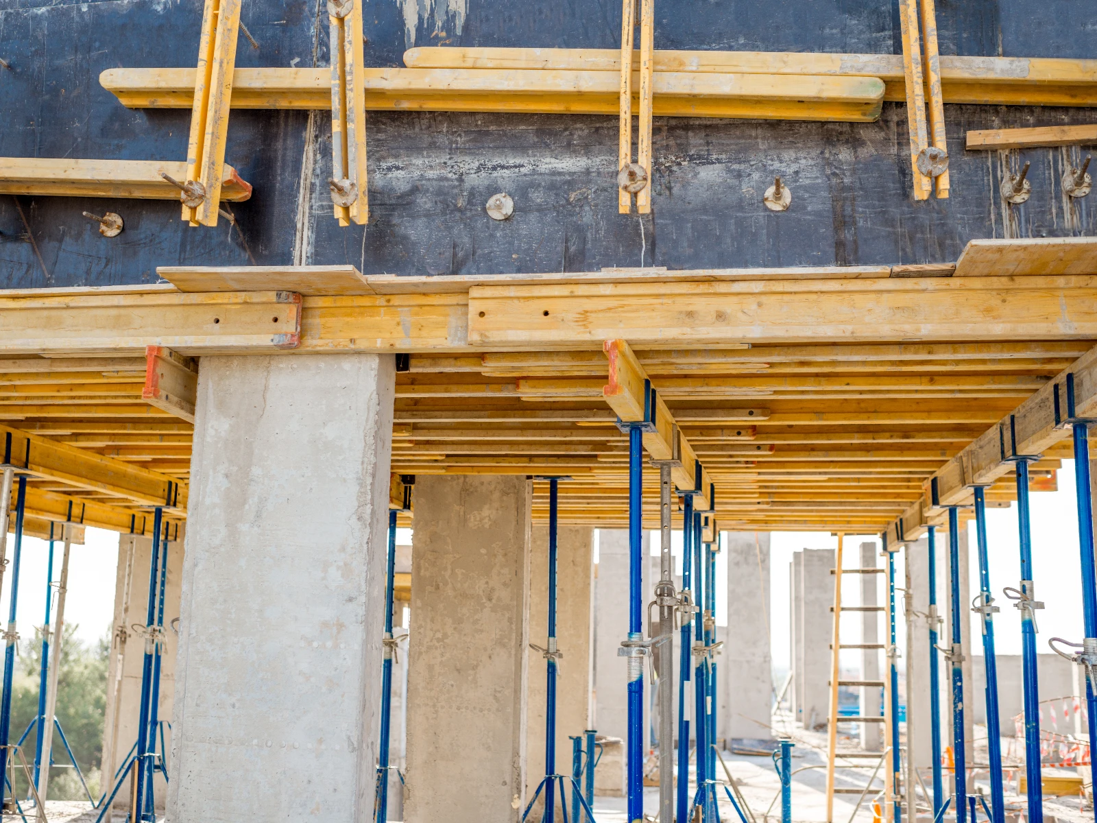 Stropy: drewniany szalunek wsparty na metalowych podporach i betonowych filarach