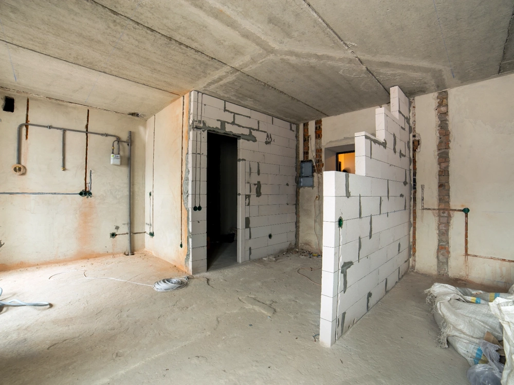 Białe bloczki murowanej ścianki działowej w surowym wnętrzu budynku Ściany działowe