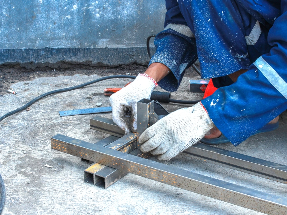 Ręczny montaż prefabrykacji stalowych elementów konstrukcyjnych na betonowym podłożu