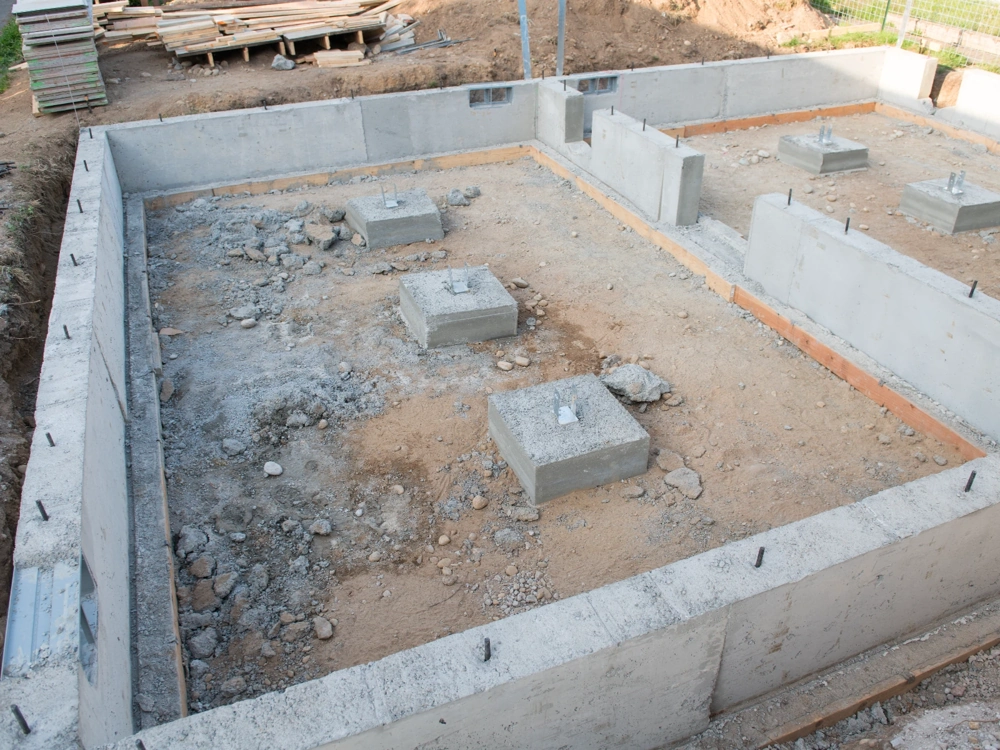 Ławy fundamentowe i betonowe podstopki w wykopie przygotowane pod dalsze prace