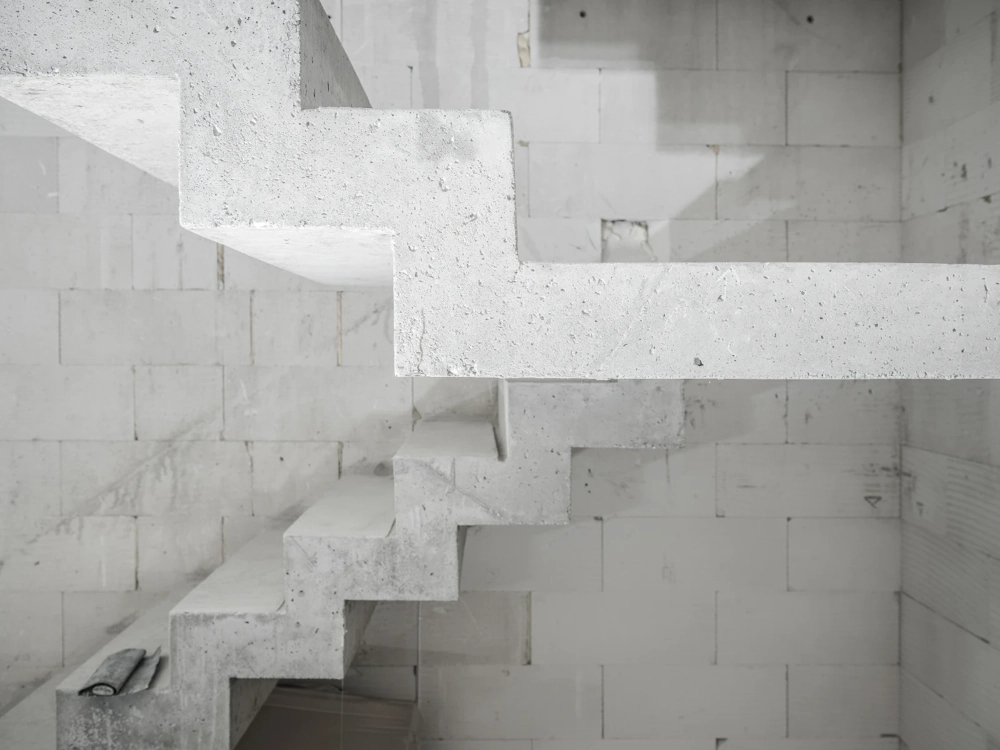 Surowe schody betonowe wewnątrz nieotynkowanej konstrukcji ścian z bloczków