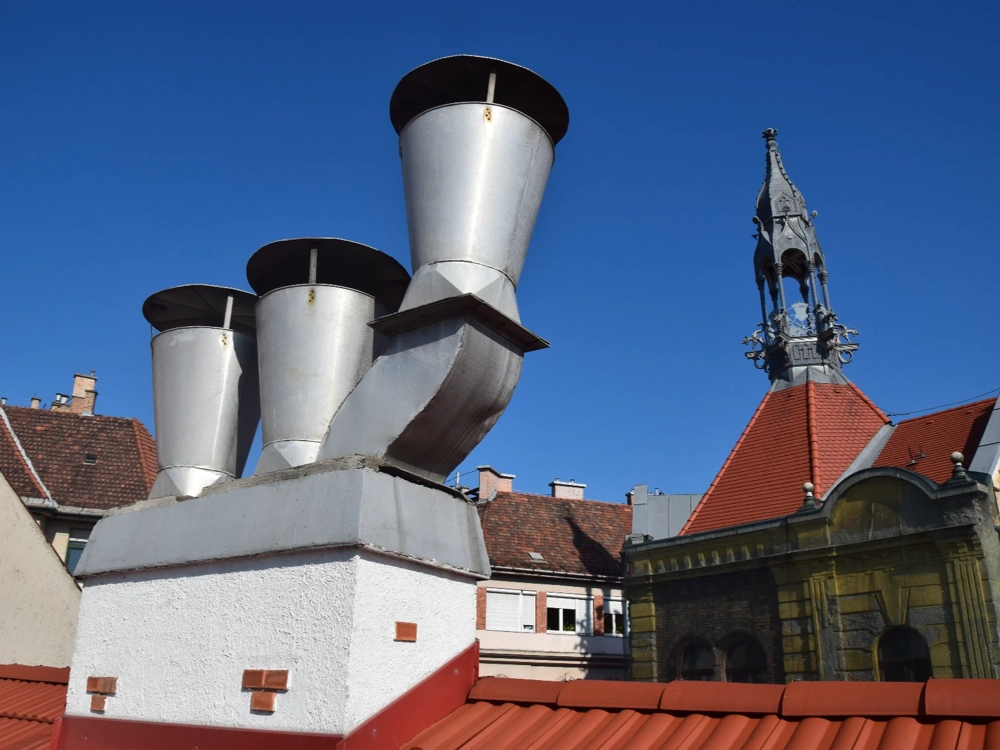 Kominy wentylacyjne z blachy na dachu pokrytym czerwoną dachówką