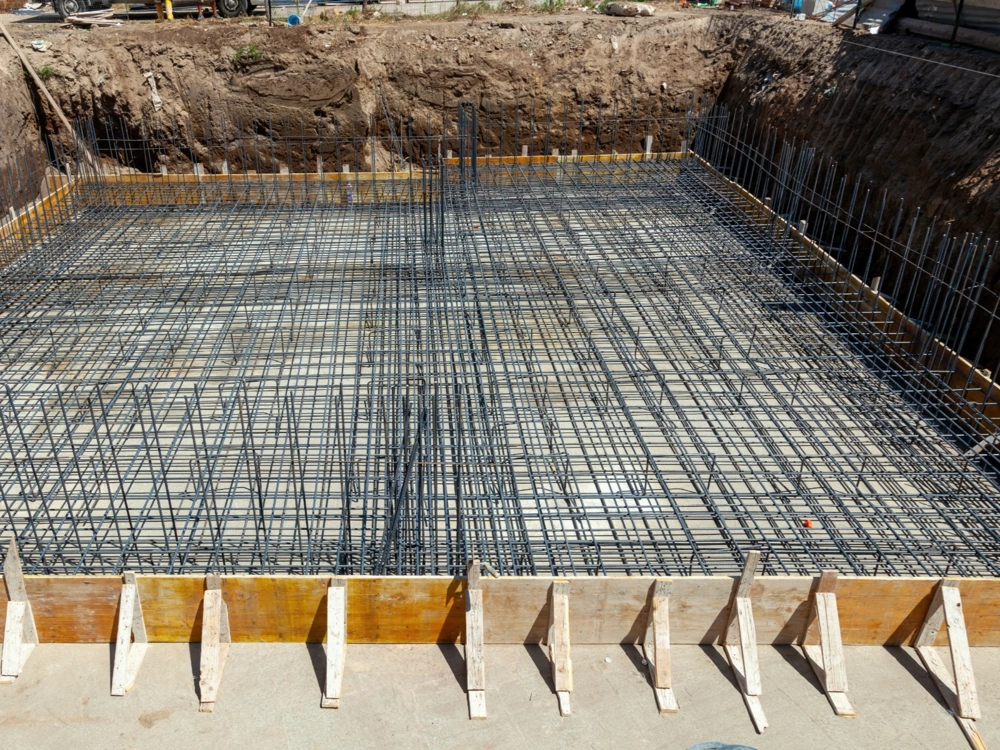 Zbrojenie fundamentów z siatką stalową i deskowaniem w wykopie